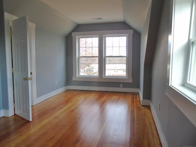 bonus room featuring lofted ceiling and light wood-type flooring