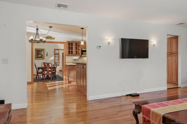 living room with a notable chandelier and light wood-type flooring