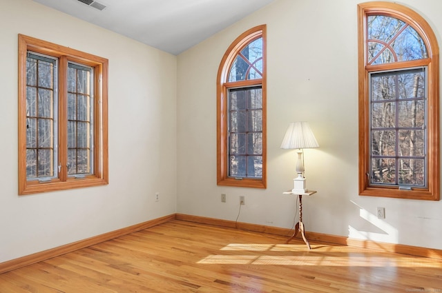 unfurnished room with hardwood / wood-style floors and plenty of natural light