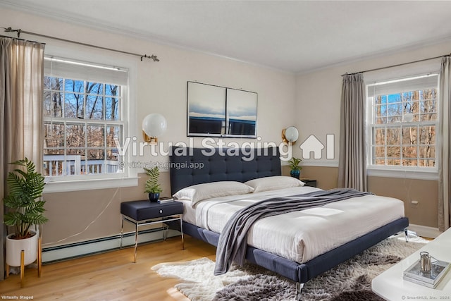 bedroom with ornamental molding, wood-type flooring, baseboard heating, and multiple windows