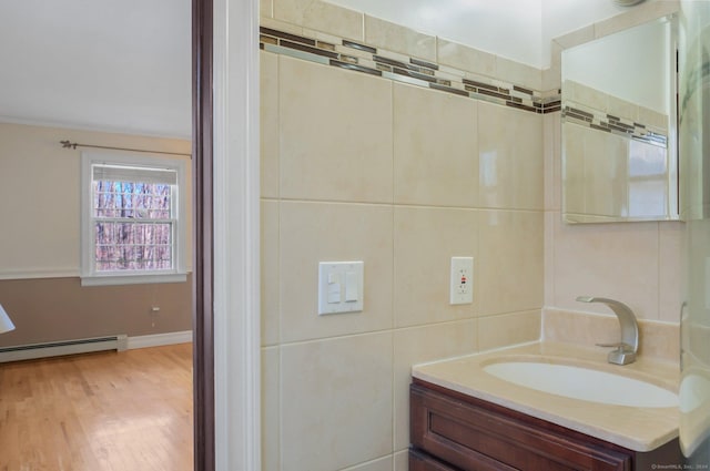 bathroom featuring wood-type flooring, vanity, and a baseboard heating unit