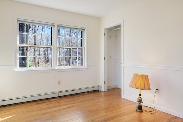 spare room featuring light wood-type flooring and a baseboard radiator