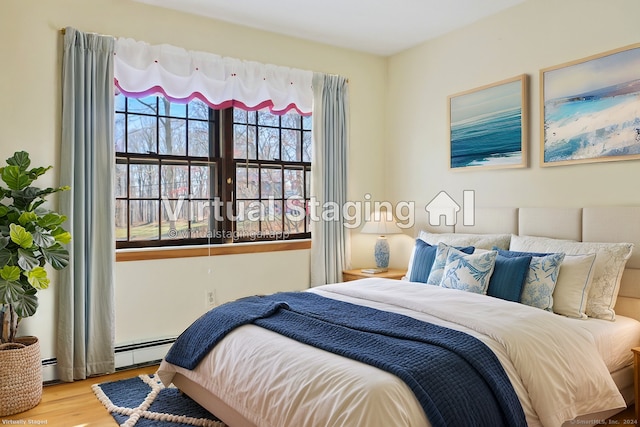 bedroom with light hardwood / wood-style flooring and a baseboard radiator