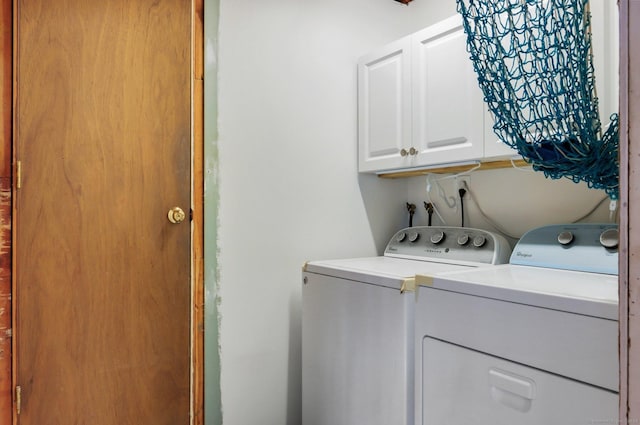 laundry area featuring washer and dryer and cabinets