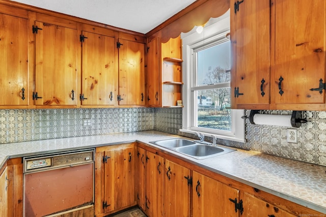 kitchen featuring black dishwasher, sink, and tasteful backsplash