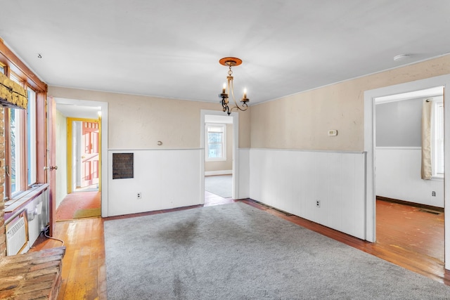 empty room featuring light hardwood / wood-style floors and an inviting chandelier