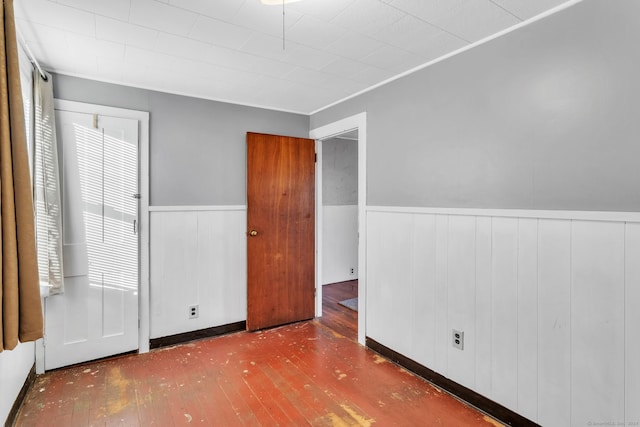 unfurnished bedroom featuring hardwood / wood-style floors and wooden walls