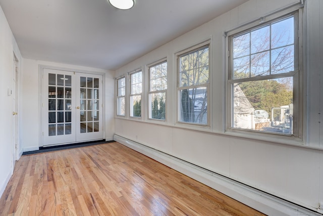 unfurnished sunroom featuring french doors, a wealth of natural light, and a baseboard radiator