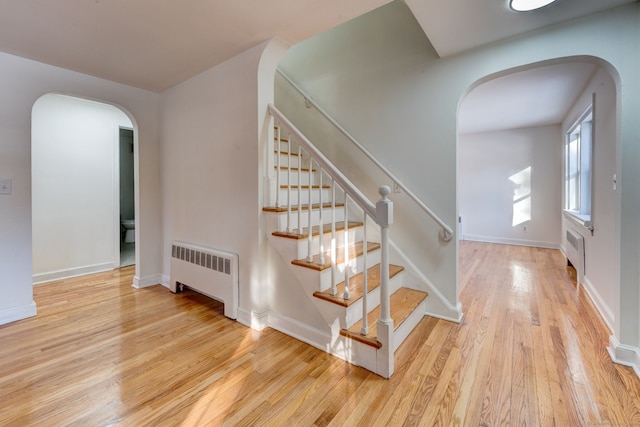 stairway featuring wood-type flooring and radiator heating unit