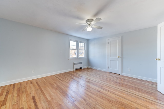 unfurnished room featuring radiator, ceiling fan, and light hardwood / wood-style flooring