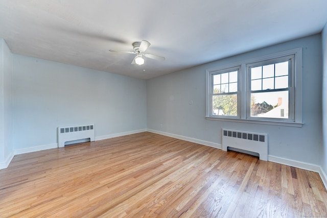 empty room featuring ceiling fan, radiator heating unit, and light hardwood / wood-style flooring