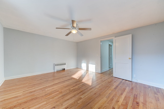 unfurnished room featuring light hardwood / wood-style floors, radiator, and ceiling fan