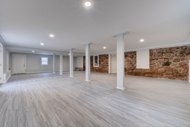 basement with light hardwood / wood-style floors and a fireplace