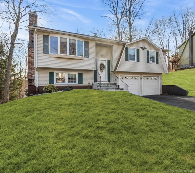 bi-level home featuring a garage and a front lawn