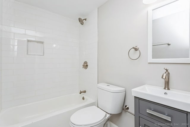 full bathroom with vanity, tiled shower / bath combo, and toilet