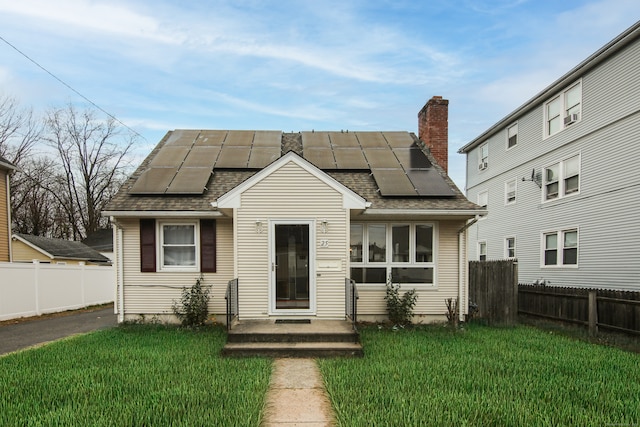 view of front of house with a front yard and solar panels