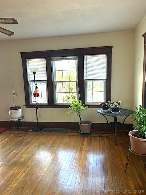 sitting room featuring wood-type flooring and ceiling fan