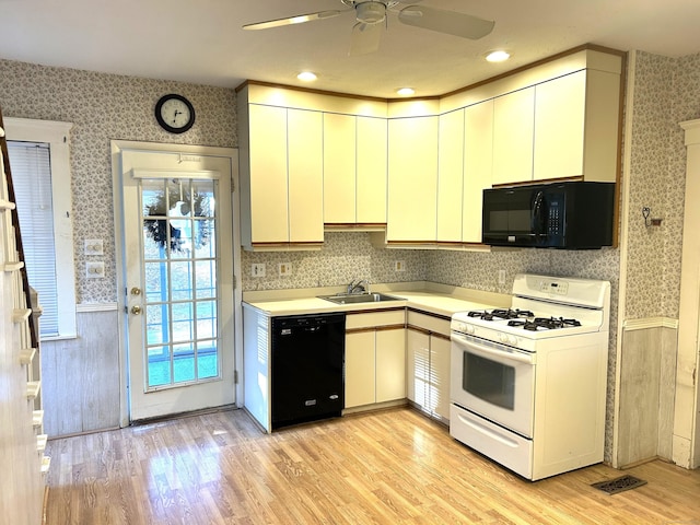 kitchen featuring black appliances, ceiling fan, sink, and light hardwood / wood-style flooring