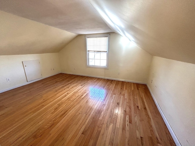 bonus room featuring vaulted ceiling and light wood-type flooring