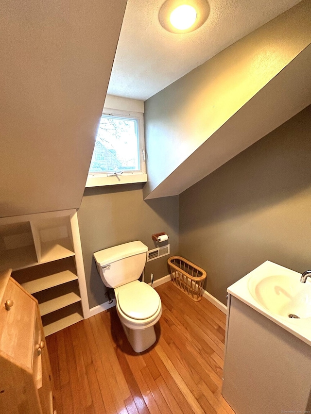 bathroom featuring hardwood / wood-style floors, vanity, a textured ceiling, and toilet