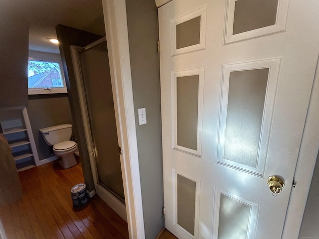 bathroom featuring hardwood / wood-style flooring, toilet, and walk in shower