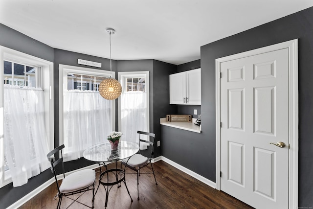 dining room with a healthy amount of sunlight and dark wood-type flooring