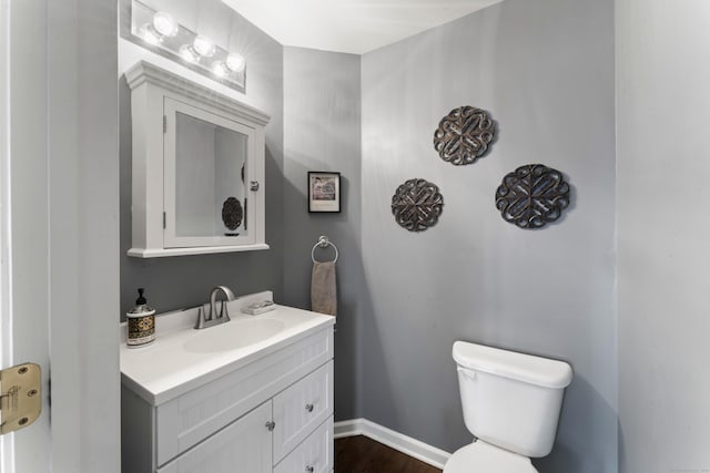 bathroom with vanity, wood-type flooring, and toilet