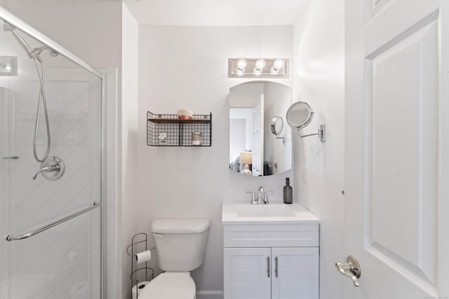 bathroom featuring a shower with door, vanity, and toilet