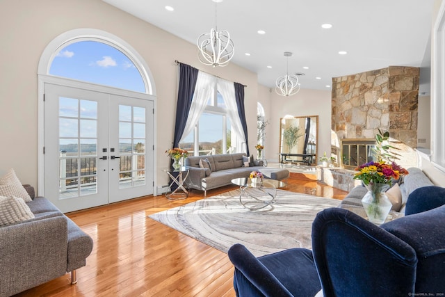 living room featuring a notable chandelier, plenty of natural light, light hardwood / wood-style flooring, and french doors