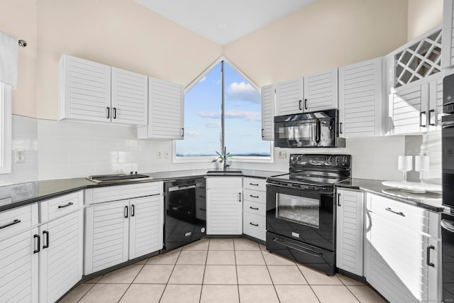 kitchen with tasteful backsplash, white cabinetry, and black appliances