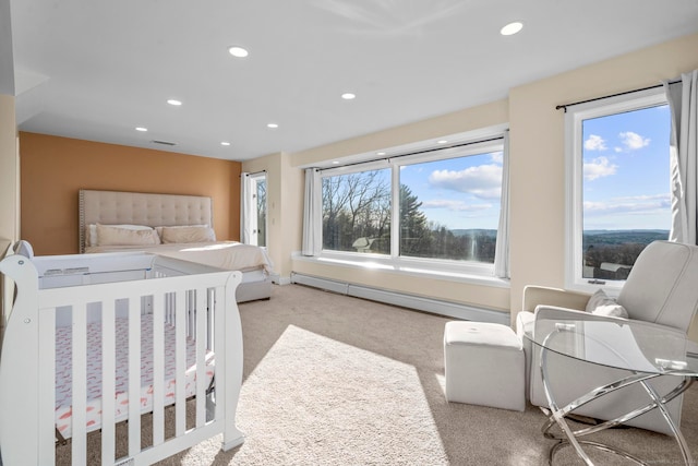 carpeted bedroom with multiple windows and a baseboard heating unit