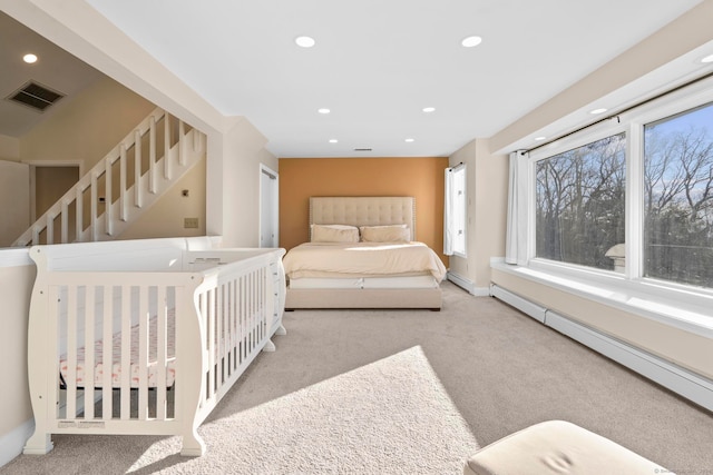 bedroom featuring light carpet and a baseboard heating unit