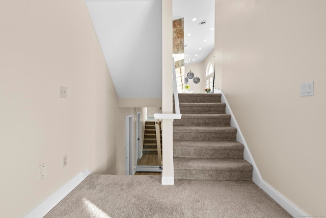 stairs with carpet floors and a baseboard heating unit