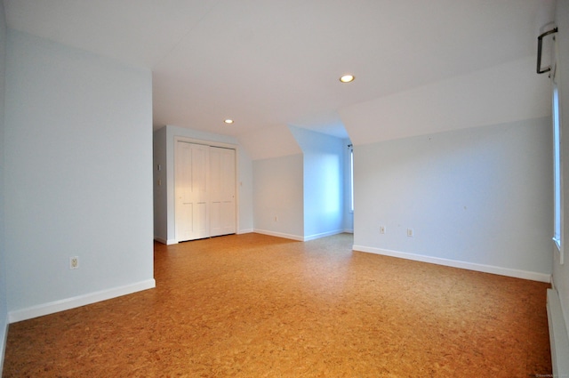 empty room featuring baseboards, lofted ceiling, and recessed lighting