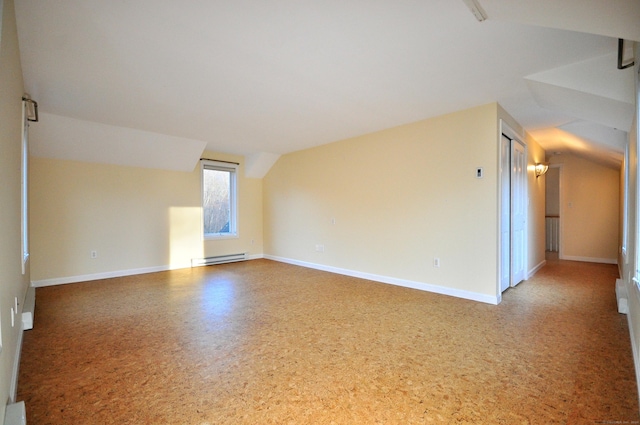 additional living space with a baseboard radiator, lofted ceiling, and baseboards