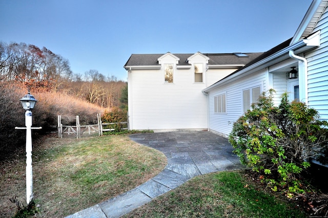 view of property exterior with a patio and fence