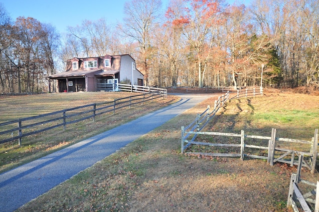 view of road featuring aphalt driveway and a barn
