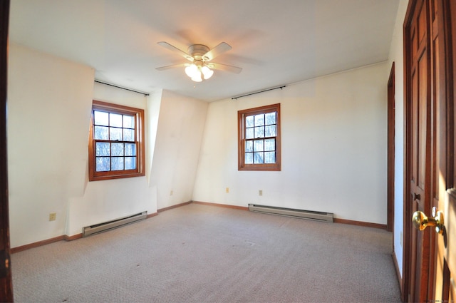 unfurnished room featuring a wealth of natural light, light colored carpet, and baseboard heating