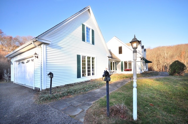 view of side of property featuring a lawn and a garage