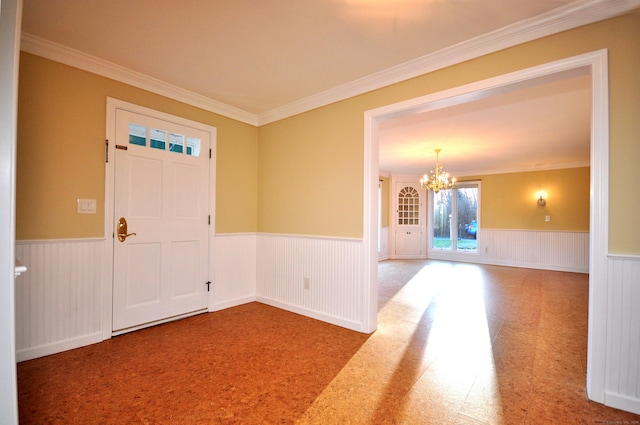 entrance foyer featuring wainscoting, an inviting chandelier, and ornamental molding