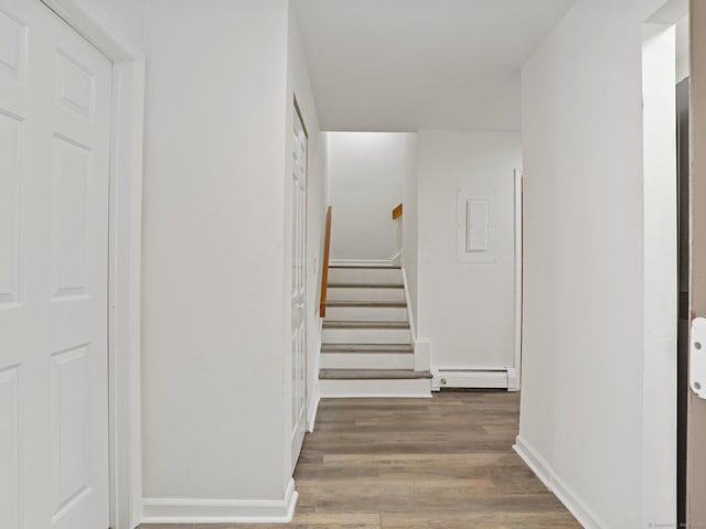 hallway with a baseboard radiator and hardwood / wood-style floors