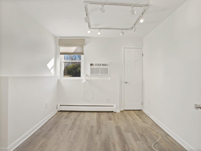 bonus room with light wood-type flooring, a wall mounted air conditioner, and a baseboard radiator