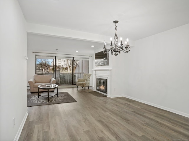 unfurnished living room with wood-type flooring and a notable chandelier