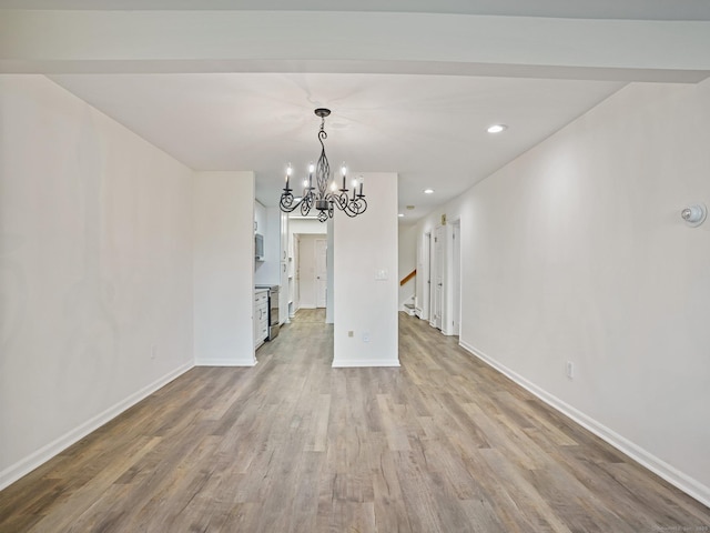 unfurnished dining area featuring light hardwood / wood-style floors and a chandelier