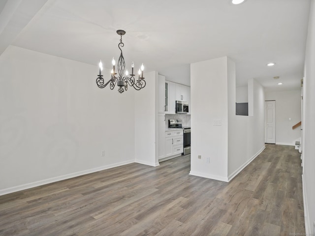 unfurnished dining area featuring wood-type flooring and a notable chandelier