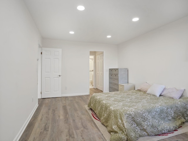 bedroom featuring ensuite bathroom and hardwood / wood-style floors