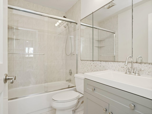 full bathroom featuring toilet, shower / bath combination with glass door, and vanity