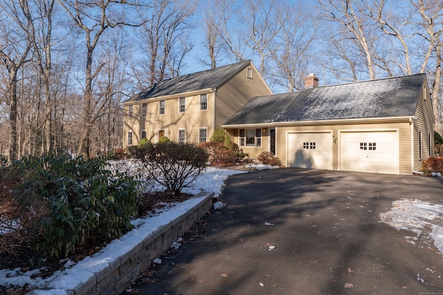 snow covered property with a garage