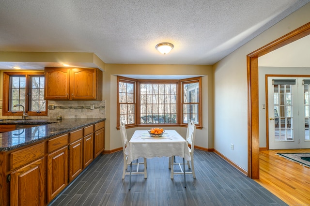 unfurnished dining area featuring a textured ceiling, dark hardwood / wood-style flooring, and sink