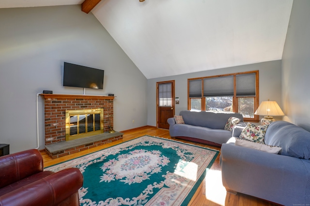 living room featuring beamed ceiling, light wood-type flooring, high vaulted ceiling, and a brick fireplace